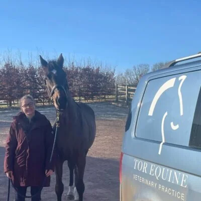 Tor Equine Vets team member beside a practice vehicle